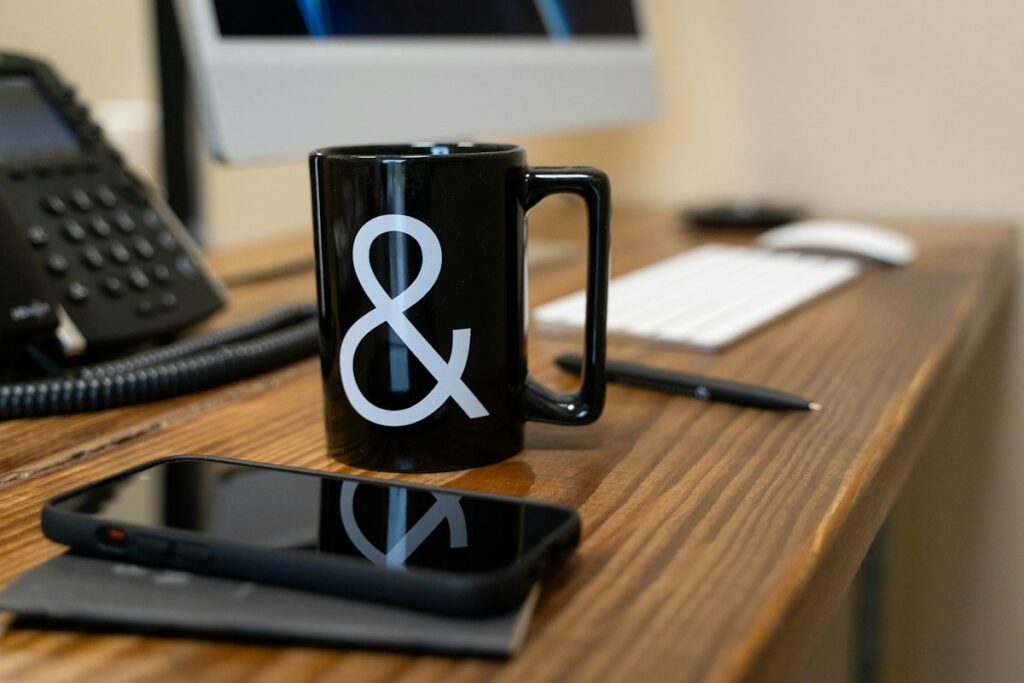 Holiday Gifts for Coworkers and Clients That Don’t Feel Generic 6 Black coffee mug on a wooden desk